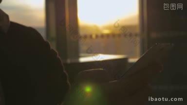 一个穿着西装的人在机场候机楼使用智能手机的特写镜头，背景是傍晚的阳光